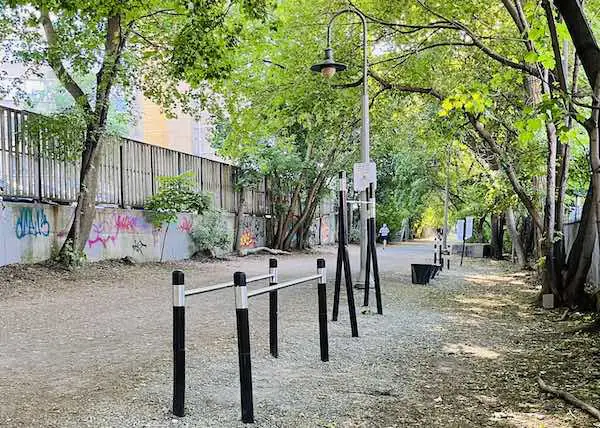calithenics outdoor gym in Toronto along the Beltline trail with graffiti in the background