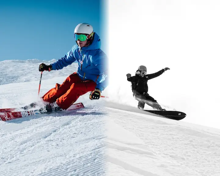 person in blue ski jacket and red ski pants skiing downhill and person in black jacket riding on snowboard downhill