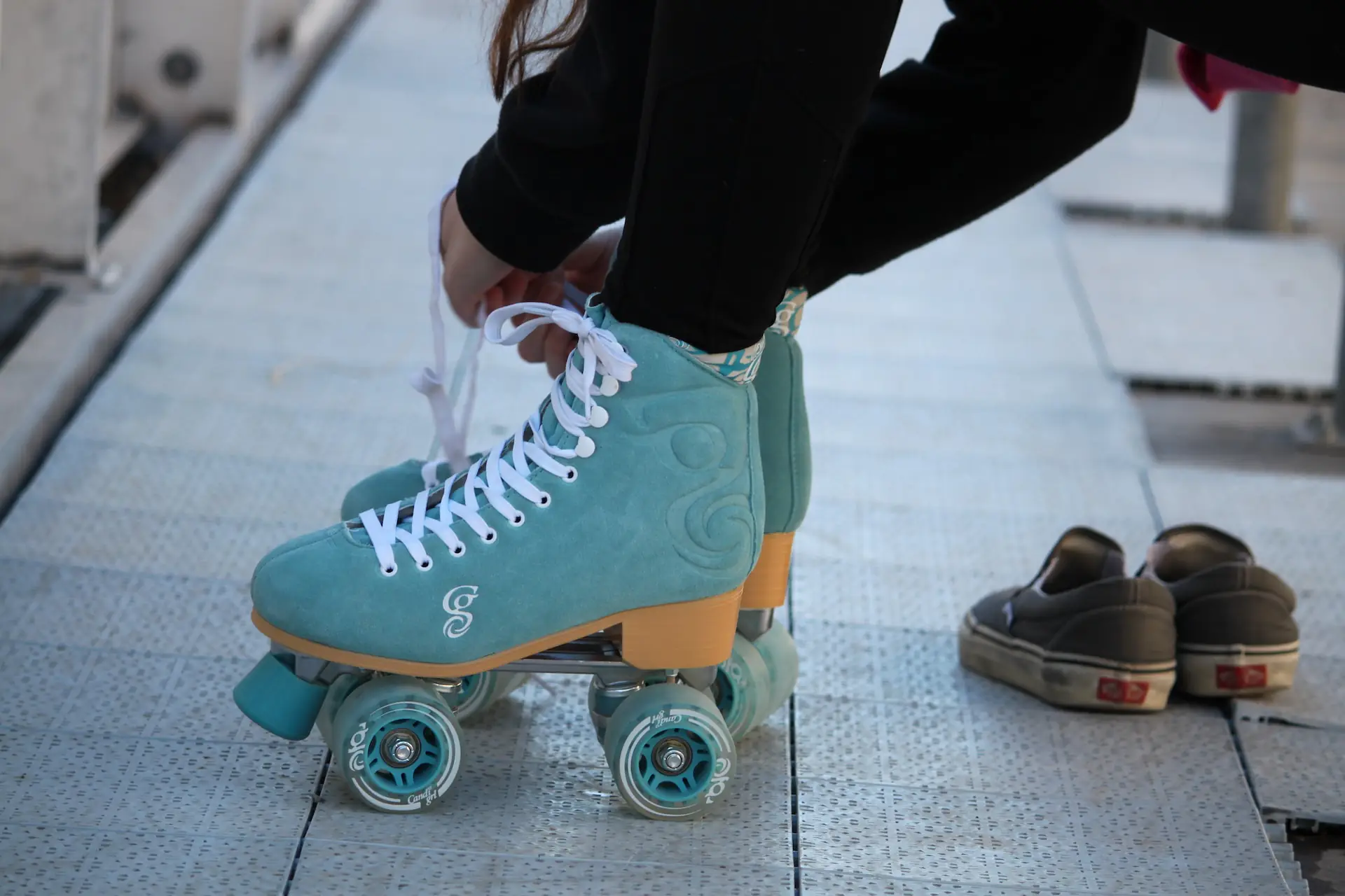 person putting on rollerskates in teel colour