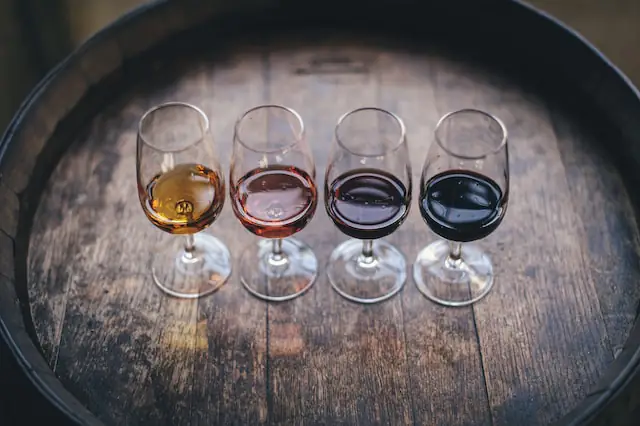 gradual different shades of wine on a barrel for wine tasting - 4 glasses in total